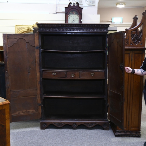 3 - An 19th century oak 2-door cupboard, with 2 heavily relief carved fielded panelled doors, carved and... 