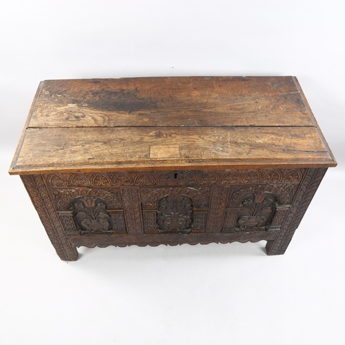 41 - A Charles I oak coffer, with plank lid, the front with 3 panels each carved with a vase of flowers w... 