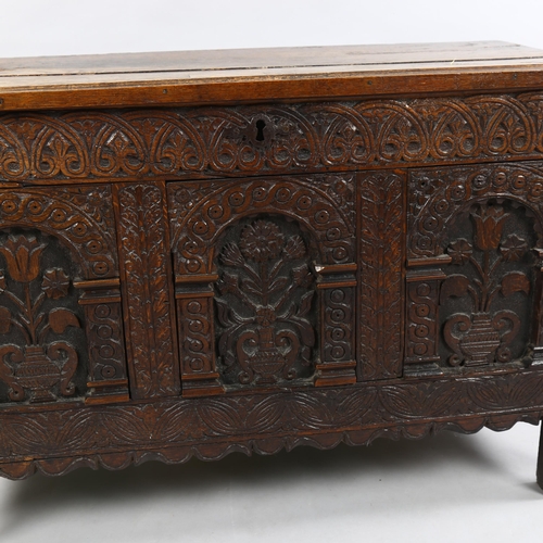 41 - A Charles I oak coffer, with plank lid, the front with 3 panels each carved with a vase of flowers w... 