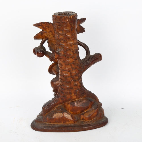 59 - A German Black Forest carved figural candlestick, depicting boy picking fruit from a tree, height 18... 