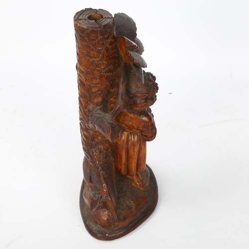 59 - A German Black Forest carved figural candlestick, depicting boy picking fruit from a tree, height 18... 