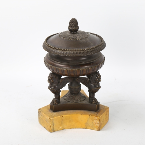 71 - A 19th century patinated bronze urn-shaped ink stand and cover, supported by winged lion figures on ... 