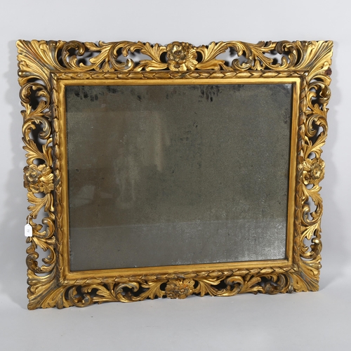 73 - An ornate 19th century carved giltwood framed rectangular wall mirror, swept acanthus leaf decorated... 