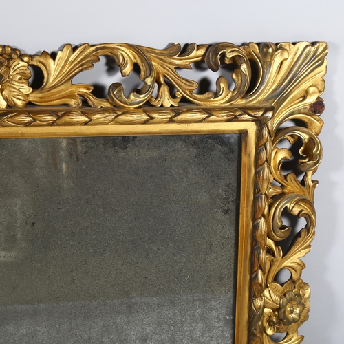 73 - An ornate 19th century carved giltwood framed rectangular wall mirror, swept acanthus leaf decorated... 