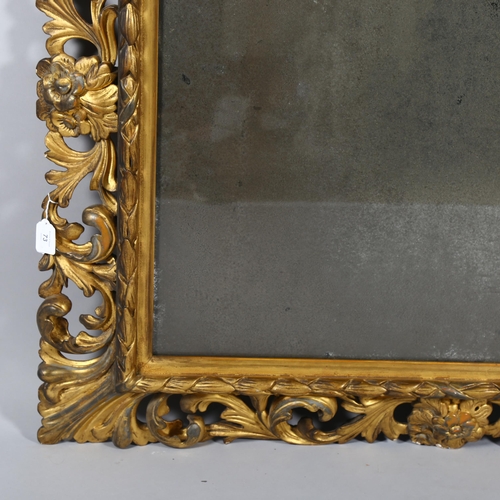 73 - An ornate 19th century carved giltwood framed rectangular wall mirror, swept acanthus leaf decorated... 