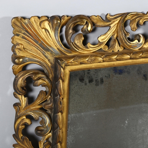 73 - An ornate 19th century carved giltwood framed rectangular wall mirror, swept acanthus leaf decorated... 