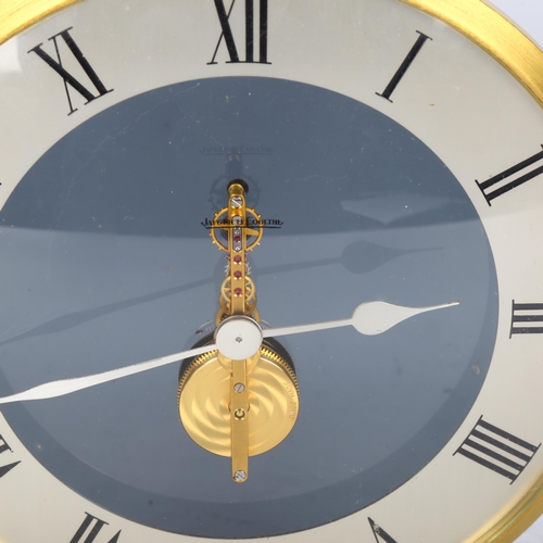 121 - JAEGER LECOULTRE - a brass-cased mantel clock, dome glass front with visible mechanism and perspex s... 