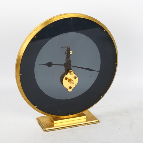 121 - JAEGER LECOULTRE - a brass-cased mantel clock, dome glass front with visible mechanism and perspex s... 