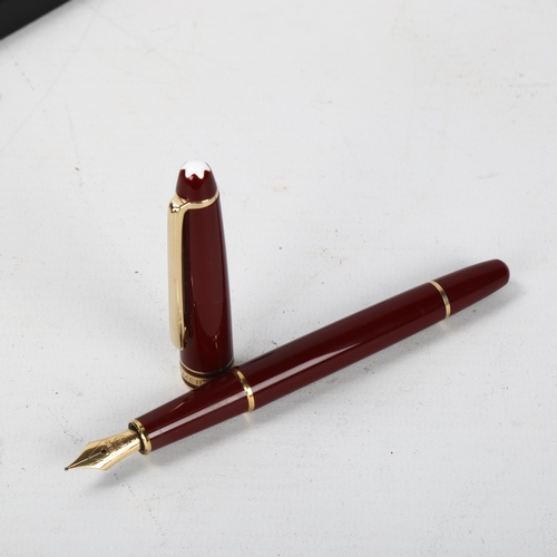 153 - A Mont Blanc Meisterstuck fountain pen with burgundy body and gold metal trim, 14K gold nib, box and... 