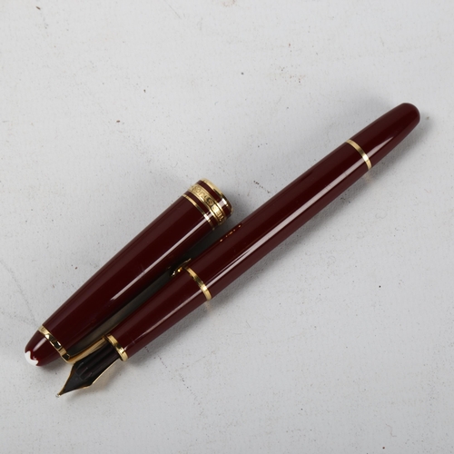 153 - A Mont Blanc Meisterstuck fountain pen with burgundy body and gold metal trim, 14K gold nib, box and... 