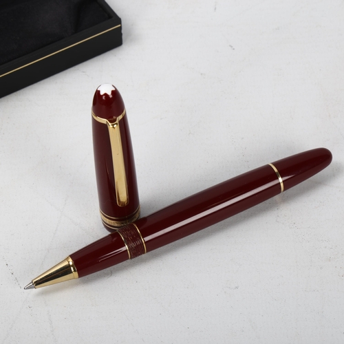 154 - A Mont Blanc Meisterstuck ballpoint pen with burgundy and gold metal body, box and service guide