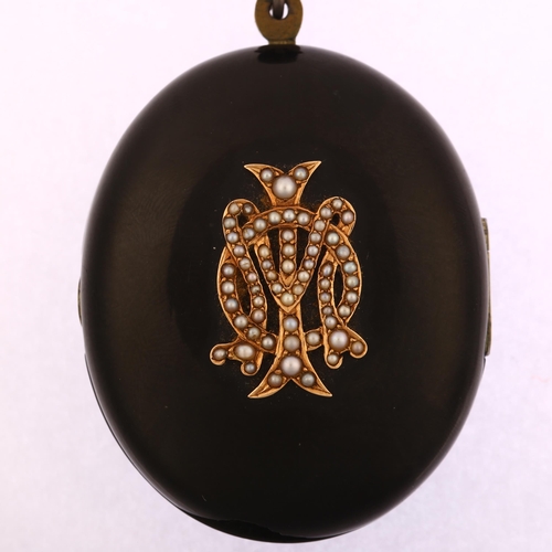 1118 - A large Victorian jet mourning locket pendant, circa 1880, with applied gold and split pearl monogra... 