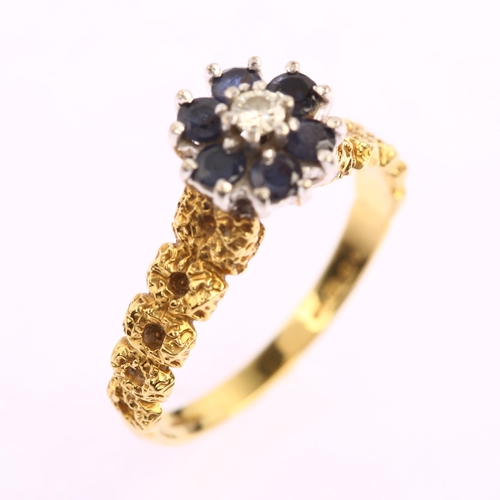 1131 - A late 20th century 18ct gold sapphire and diamond cluster flowerhead ring, with textured shoulders,... 