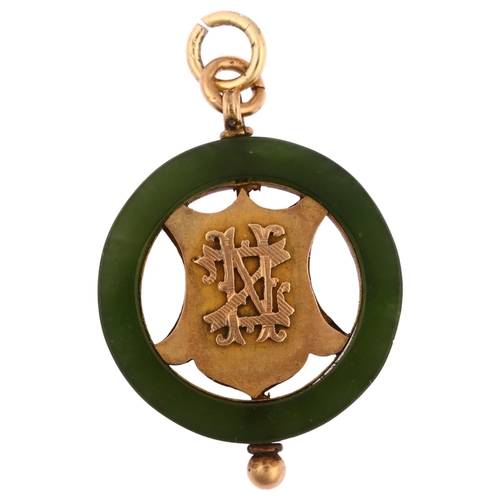 1156 - An early 20th century New Zealand nephrite pendant, circular form with openwork central shield, appl... 