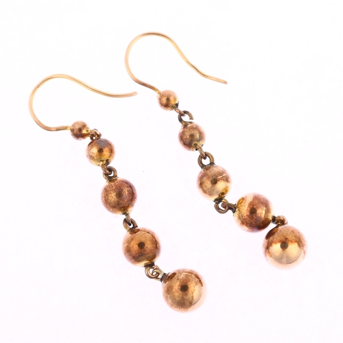 1173 - A pair of graduated ball drop earrings, unmarked yellow metal settings, with shepherd hook fittings,... 