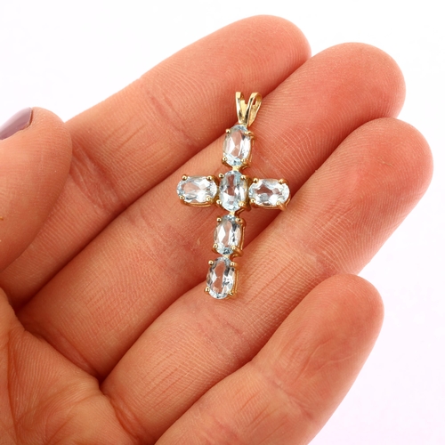 1208 - A modern 9ct gold blue topaz cross pendant, prong set with oval mixed-cut topaz, pendant height 31mm... 