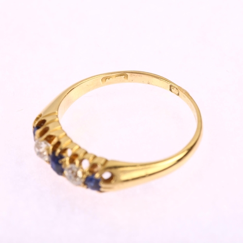 1211 - An early 20th century 18ct gold graduated five stone sapphire and diamond half hoop ring, set with o... 