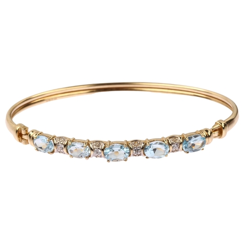 1219 - A modern 9ct gold blue topaz and cubic zirconia torque bangle, band width 5.6mm, internal circumfere... 