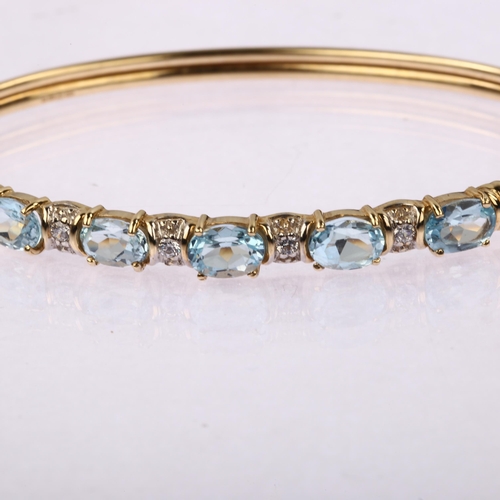 1219 - A modern 9ct gold blue topaz and cubic zirconia torque bangle, band width 5.6mm, internal circumfere... 