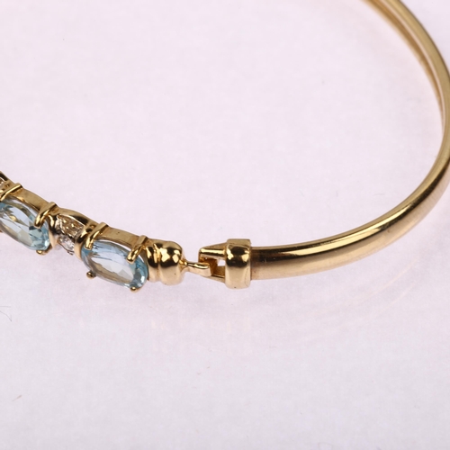 1219 - A modern 9ct gold blue topaz and cubic zirconia torque bangle, band width 5.6mm, internal circumfere... 