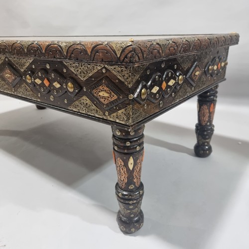 263 - An ornate Moroccan centre table, made from an Antique studded and metal inlaid door behind a glass p... 