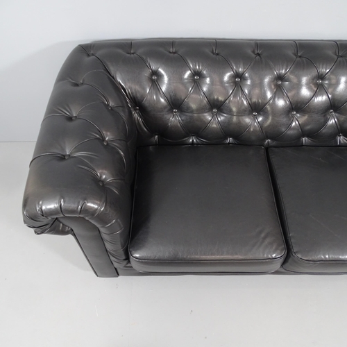 2052 - A two-seater black button-back leather upholstered Chesterfield style sofa. Overall 188x80x90cm. Sea... 