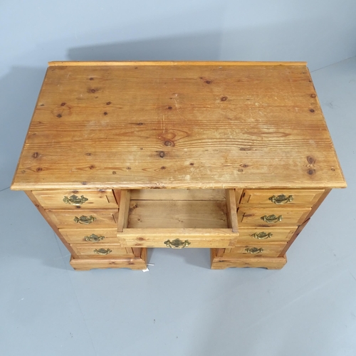 2061 - A modern pine kneehole desk, with nine drawers and recessed cupboard. Overall 101x78x56cm, kneehole ... 