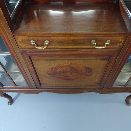 2067 - An Edwardian mahogany display cabinet, with two lattice glazed doors, mirrored back and centre drawe... 