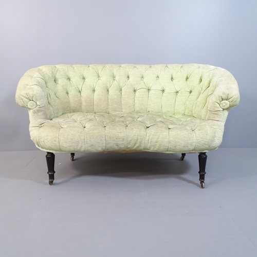 2075 - An early 20th century button-back upholstered loveseat or two-seater sofa, raised on turned ebonised... 