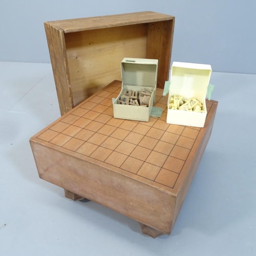 2078 - A Japanese Shogi set comprising a wooden game board and counters. 35x21x31cm.