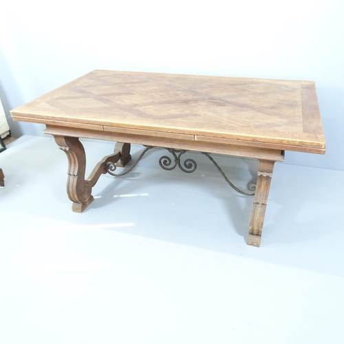 2129 - A Spanish oak draw-leaf dining table with wrought iron stretcher. 170 (extends to 290cm)x75x100cm.