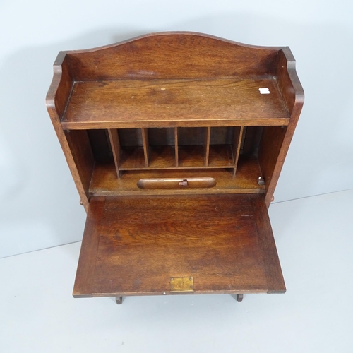 2137 - A 1920s oak student's bureau, the fall front revealing a fitted interior with shelves beneath. 62x10... 