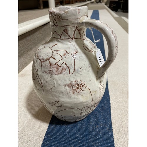 509 - A handbuilt earthenware art jug with sgraffito decoration, artist initals L.C. to base, height 25cm