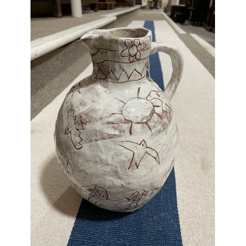 509 - A handbuilt earthenware art jug with sgraffito decoration, artist initals L.C. to base, height 25cm