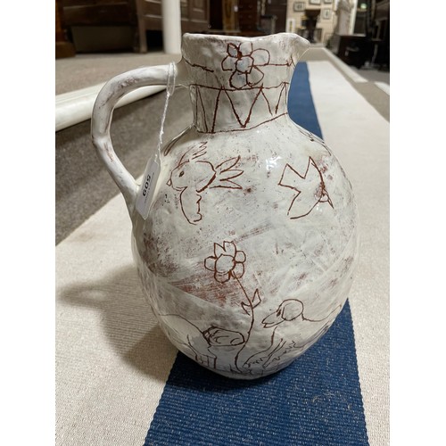 509 - A handbuilt earthenware art jug with sgraffito decoration, artist initals L.C. to base, height 25cm