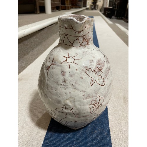 509 - A handbuilt earthenware art jug with sgraffito decoration, artist initals L.C. to base, height 25cm