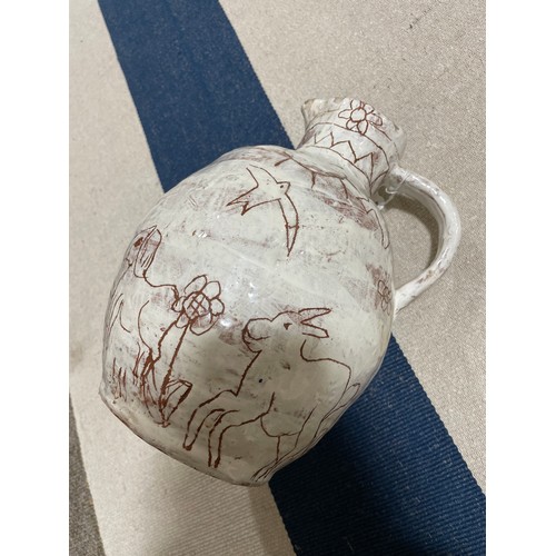 509 - A handbuilt earthenware art jug with sgraffito decoration, artist initals L.C. to base, height 25cm