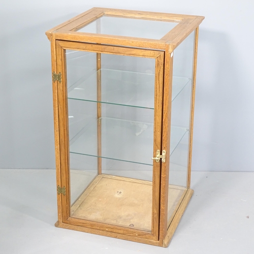 2038 - An early 20th century oak framed and glazed shop display cabinet with two glass shelves. 46x76x46cm.