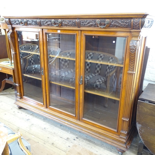 2143 - A large Victorian mahogany three door bookcase, with three frieze drawers above three glazed panelle... 