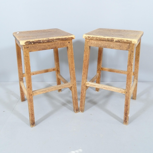 2209 - A pair of vintage oak school lab stools. 40x60x38cm.