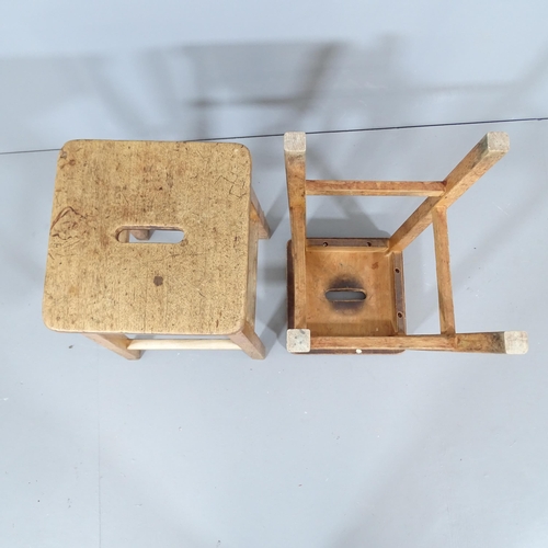 2210 - A pair of vintage oak school lab stools. 34x59x35cm.