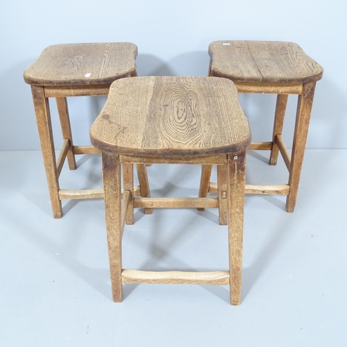 2212 - A matched set of three vintage elm-seated school lab stools. 36x52x34cm.