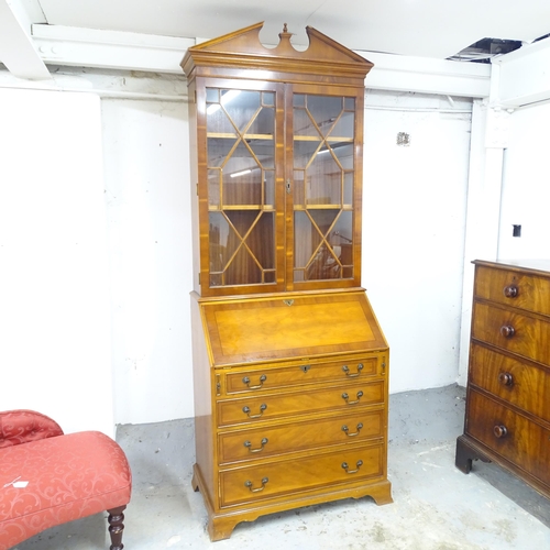 2501 - A modern crossbanded and ebony strung yew wood two-section bureau bookcase, with two glazed doors, a... 