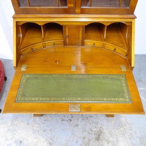 2501 - A modern crossbanded and ebony strung yew wood two-section bureau bookcase, with two glazed doors, a... 