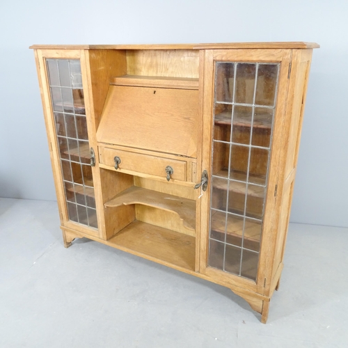 2519 - An early 20th century oak side-by-side student's bureau, with two lattice glazed doors, and fall fro... 