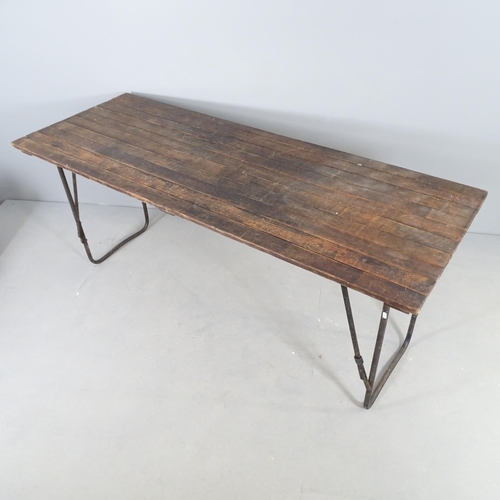 2521 - A stained teak plank top trestle table with folding metal base. 182x77x68cm.