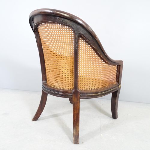 2545 - A 1930s bergere tup chair, with cane panels and oak frame.