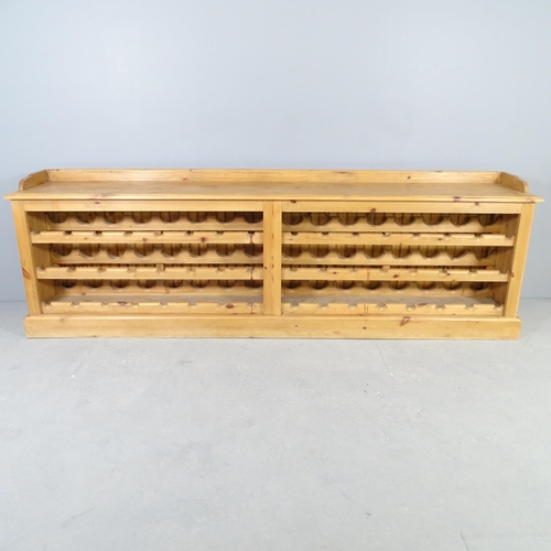 2551 - A pine 48 bottle wine rack / bench. 218x70x39cm.