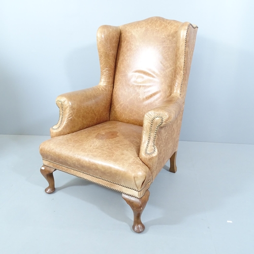 2242 - An antique studded leather upholstered wingback fireside armchair. Overall 82x110x85cm, seat 46x38x6... 