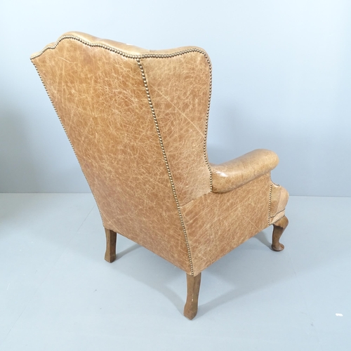 2242 - An antique studded leather upholstered wingback fireside armchair. Overall 82x110x85cm, seat 46x38x6... 